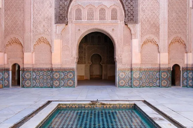 A serene courtyard in the Marrakesh palace, featuring intricate tile work and lush greenery, inviting tranquility and reflection Marrakech Tours