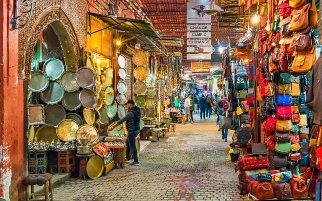 A bustling market scene in the medina of Marrakesh, showcasing vibrant stalls and diverse local goods morocco tour