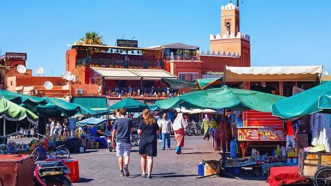 A vibrant street scene in Marrakech, showcasing colorful markets and traditional Moroccan architecture Marrakech Tours