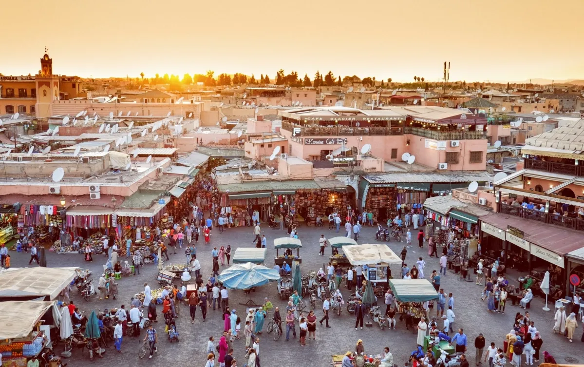 Sunset casting vibrant hues over the skyline of Marrakech, highlighting the city's unique architecture and atmosphere morocco tour