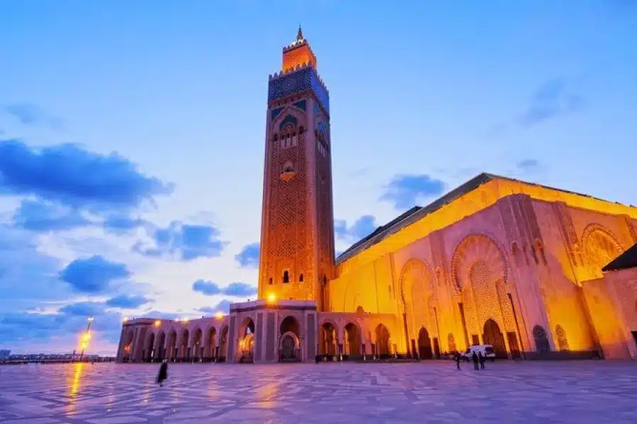 The grand mosque of Casablanca illuminated at dusk, showcasing Morocco's rich heritage and architectural beauty.