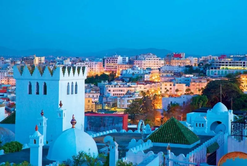 A stunning view of Marrakech at dusk, showcasing vibrant colors and the city's unique architecture, inviting travel to Tangier.