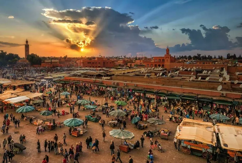 A stunning sunset casts vibrant colors over the city of Marrakech, highlighting its beauty as a must-visit destination in Morocco. 