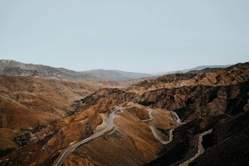 A winding road through the mountains of Morocco, showcasing the stunning landscape during a morocco road trip adventure.