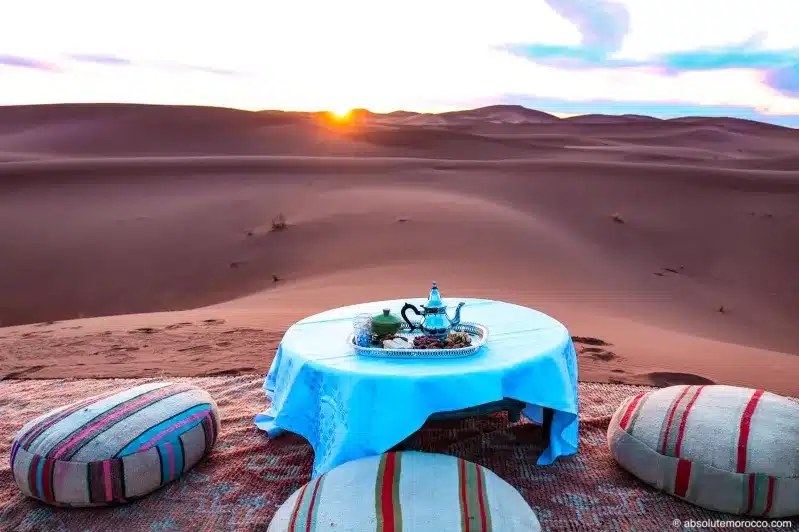 A beautifully arranged table in the desert, showcasing an elegant dining setup for private Morocco tours.