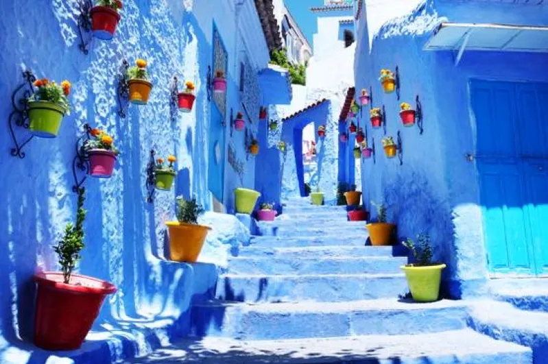 A scenic view of Chefchaouen, Morocco, showcasing its iconic blue buildings and vibrant streets, perfect for touring. 