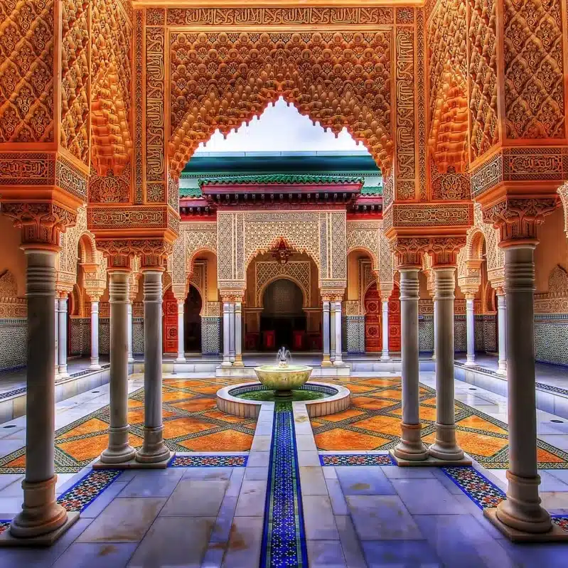 The courtyard of the royal palace in Marrakesh, Morocco, showcasing intricate architecture and vibrant greenery. 