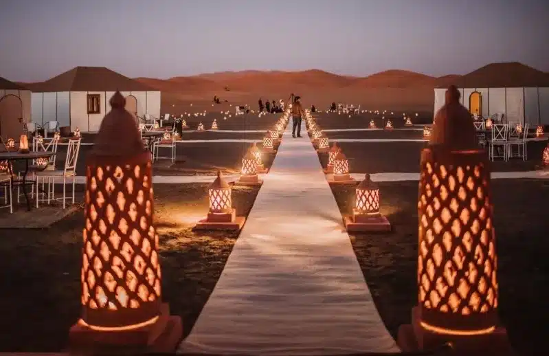 A romantic wedding ceremony in the desert, illuminated by candles, showcasing the beauty of a 7-day Morocco tour.