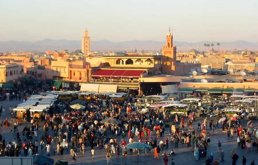 A bustling city square filled with a large crowd of diverse people enjoying the vibrant atmosphere.