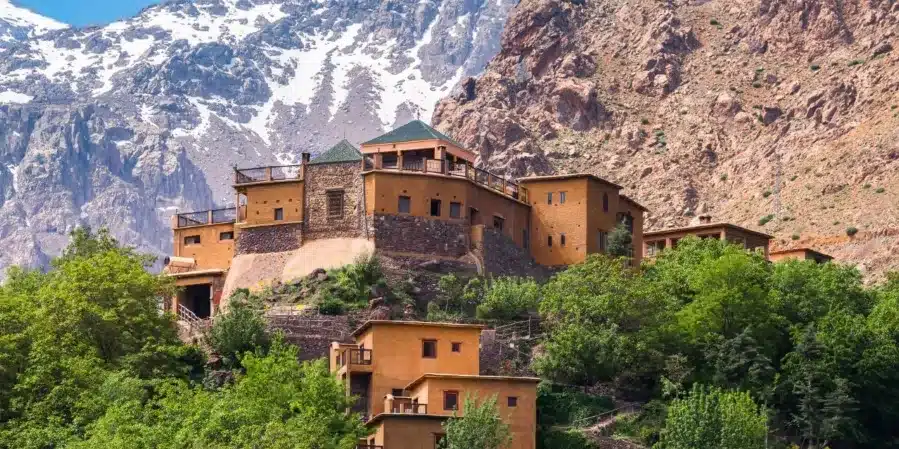 Scenic view of a Moroccan mountain village with a historic castle overlooking the landscape, perfect for travel deals.