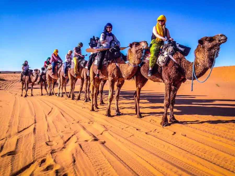 A group of travelers riding camels through the vast desert during a 10-day tour of Morocco from Casablanca.