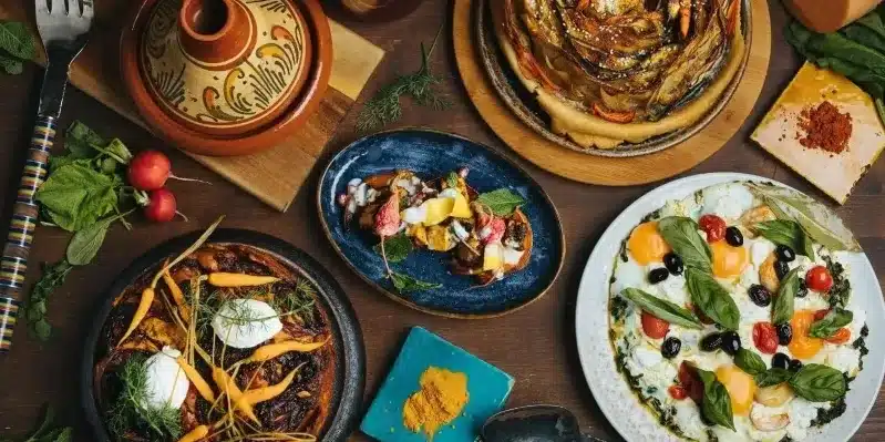 A table set with various plates of food, showcasing dishes from a Marrakech cooking class for families. 