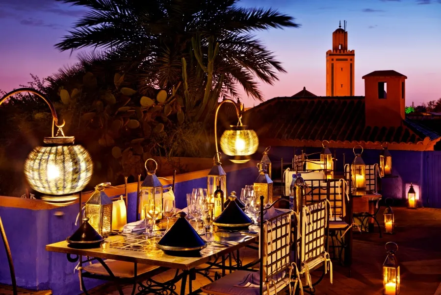 A beautifully arranged dinner table on a hotel patio, showcasing the best food in Marrakech under a serene evening sky.