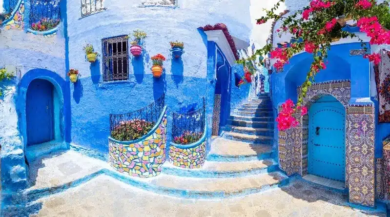 A scenic view of Chefchaouen, Morocco, showcasing its iconic blue buildings against a mountainous backdrop in North Africa.