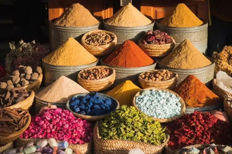 A vibrant market display featuring an array of spices and herbs, highlighting the essence of the best Moroccan dishes.