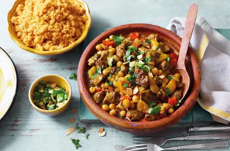 A vibrant bowl of Moroccan stew featuring rice and assorted vegetables, showcasing the rich flavors of traditional cuisine.