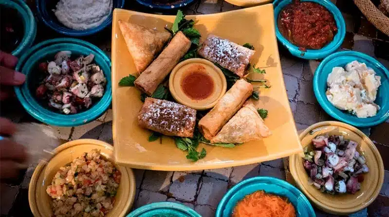 A table filled with various dishes from a Marrakech cooking class, showcasing a vibrant array of traditional foods.