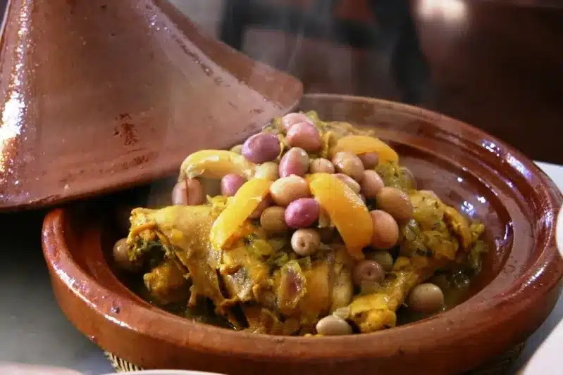 A bowl filled with vegetables, meat, and Moroccan olives, showcasing a vibrant and appetizing meal.