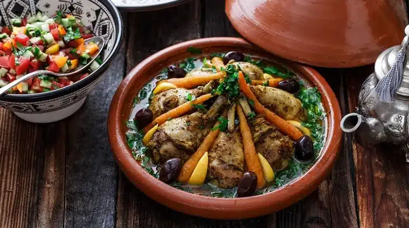 A skillet filled with chicken tagine, olives, and assorted ingredients, showcasing a vibrant and flavorful dish.