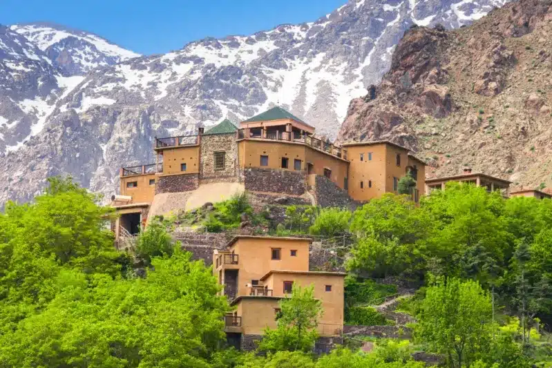 A stunning building nestled in the mountains, with a majestic mountain range visible in the background.
