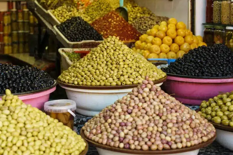 A variety of Moroccan olives displayed in bowls, showcasing their diverse colors and shapes.