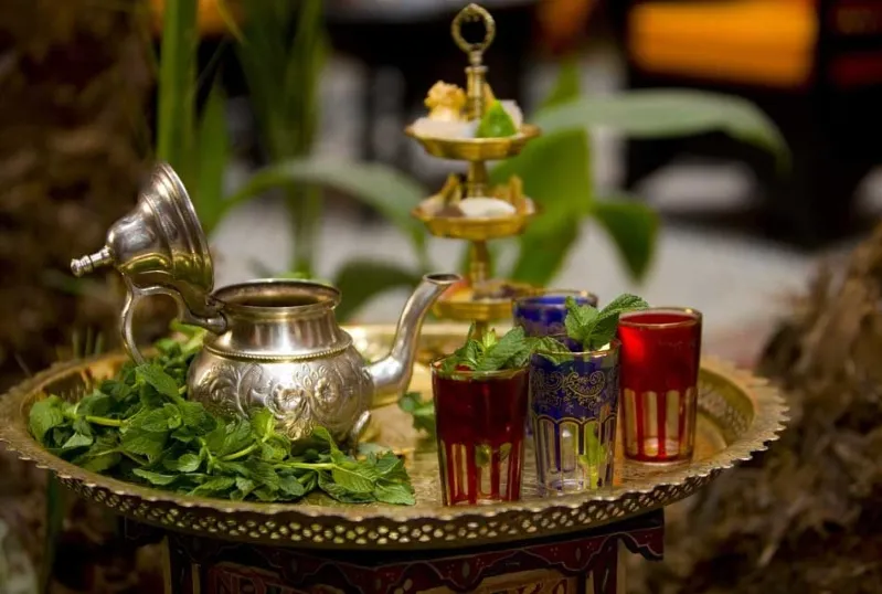 A decorative tray featuring tea and glasses, set against a festive backdrop for New Year's Eve in Marrakech.