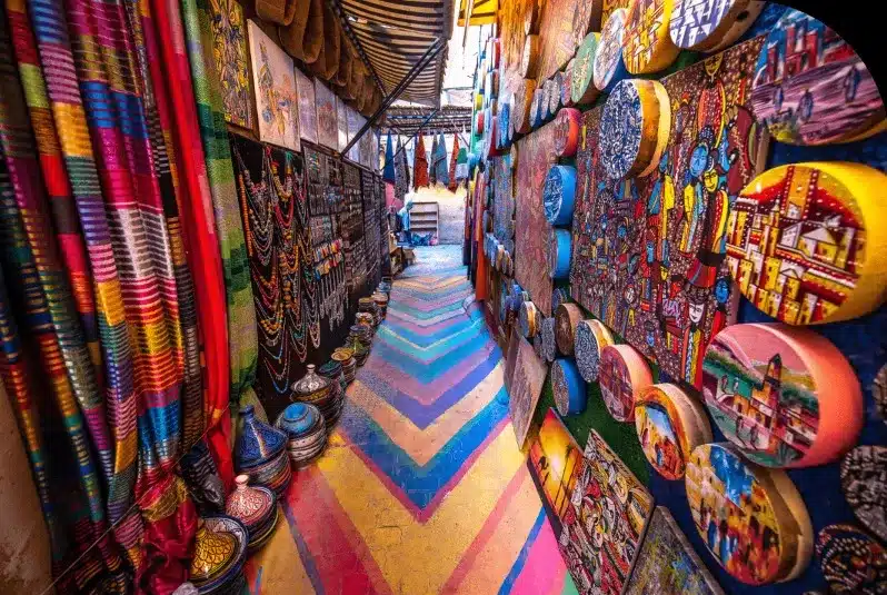 A vibrant alleyway in Morocco filled with colorful items, showcasing the lively atmosphere of the city's markets.