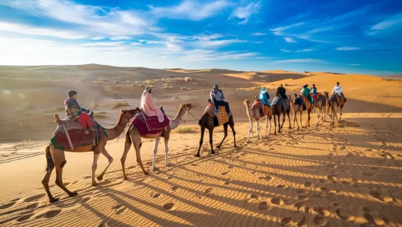 A scenic view of a camel ride in the Sahara Desert, showcasing an overnight trek in Merzouga with vast sand dunes.