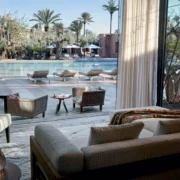 Bright living room showcasing a pool and chairs by the window, embodying the essence of Moroccan living.