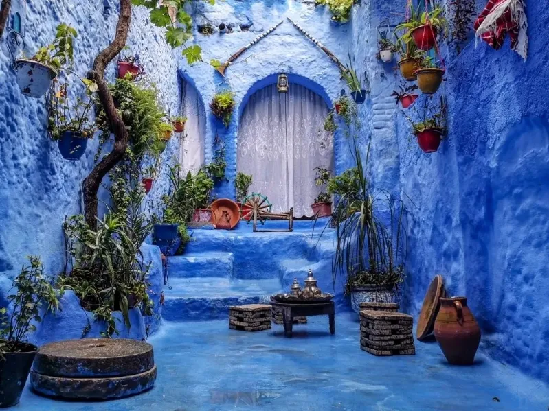 A scenic view of Chefchaouen, Morocco, showcasing its iconic blue buildings and mountainous backdrop. 