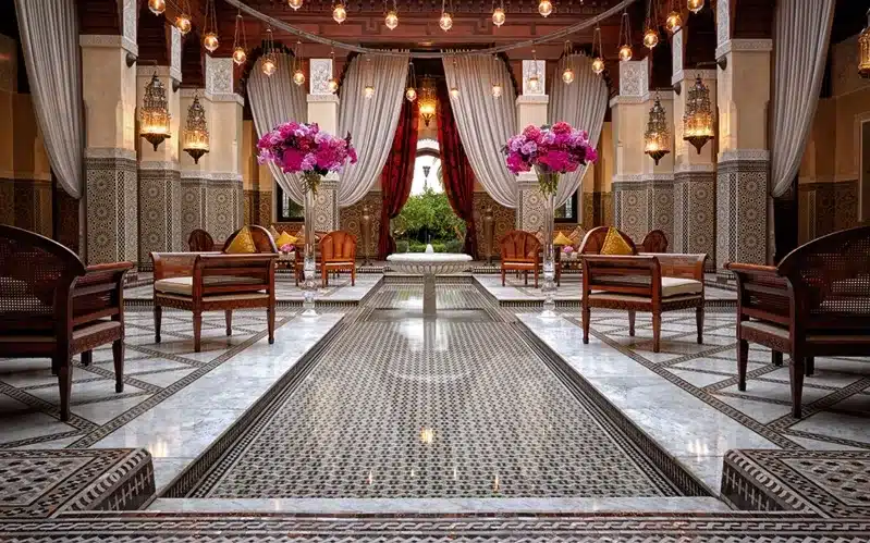 The lobby of a luxury hotel in Morocco featuring an elegant large fountain as a central focal point.