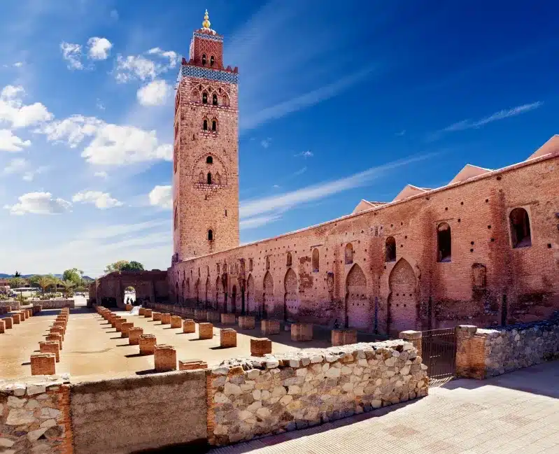 A large building featuring a prominent clock tower, associated with a Marrakech tour operator.