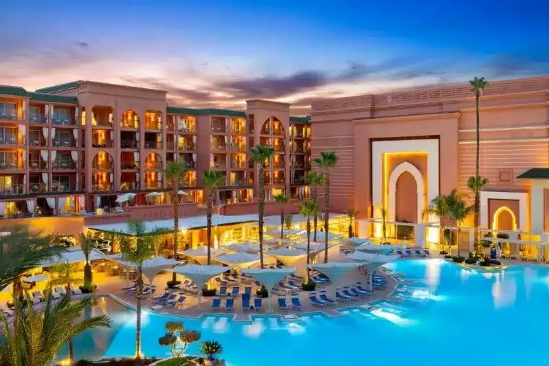 A serene view of the Luxury Hotels in Marrakech Morocco, featuring lush greenery and comfortable seating areas.