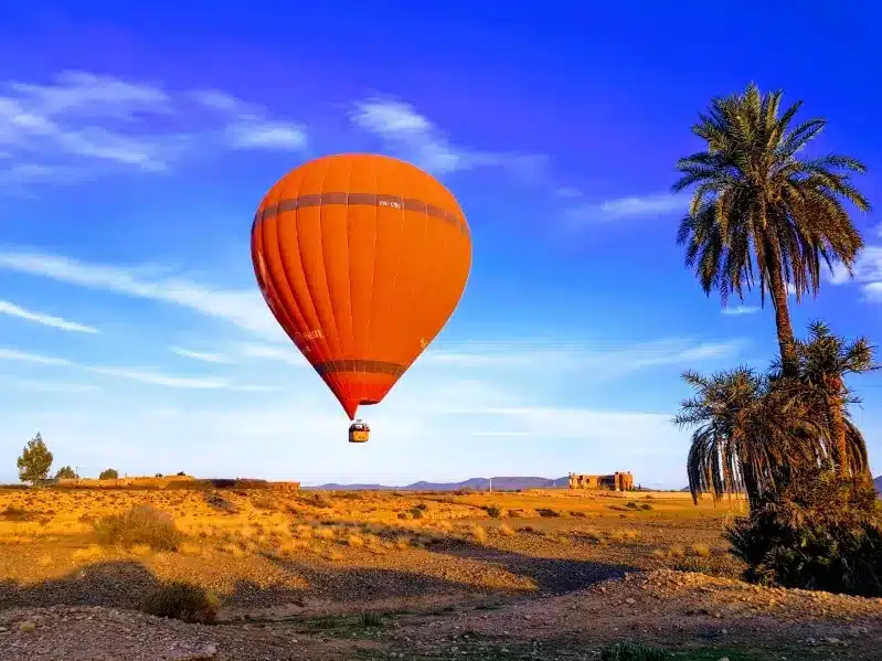 A vibrant hot air balloon floats over the vast desert, capturing the essence of the Moroccan dream.