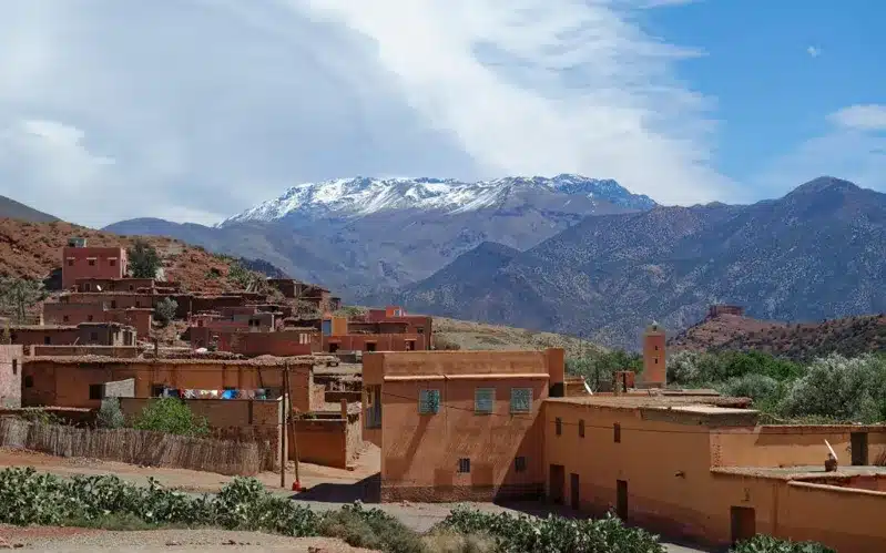 A picturesque village in the Atlas Mountains, showcasing traditional Moroccan lifestyle with mountains in the background.