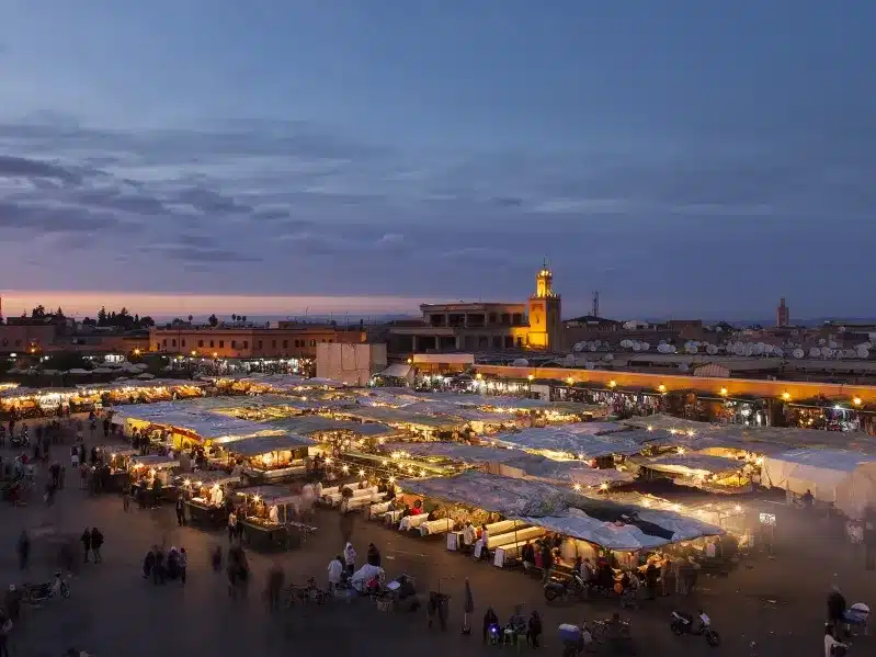 Dusk at the Marrakesh market, showcasing vibrant stalls and bustling activity, a must-visit in Morocco.
