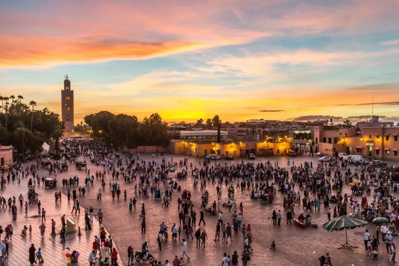 Sunset over Marrakech, Morocco, showcasing vibrant colors and silhouettes, a must-see site in Morocco.