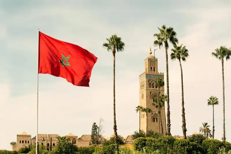 Morocco flag waving in front of the Moroccan palace, showcasing national pride against a historic architectural backdrop.