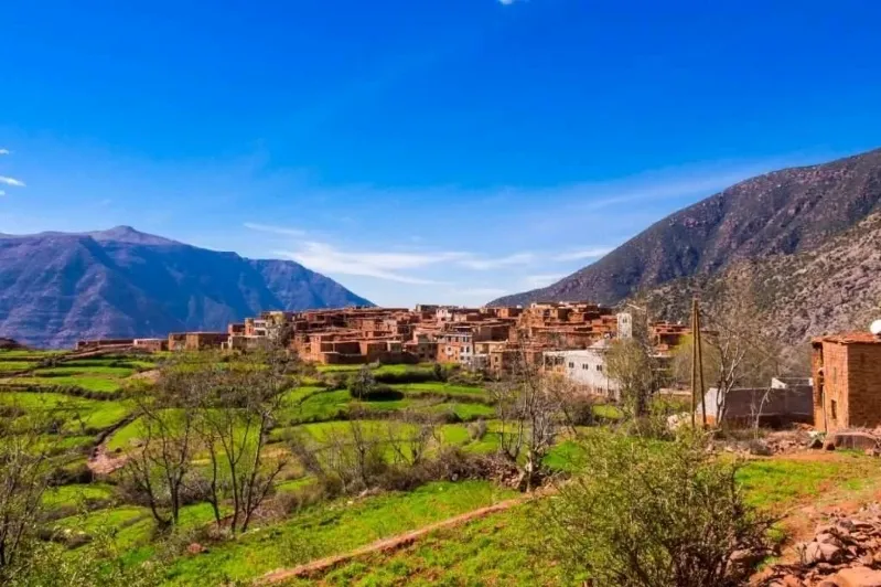 A scenic view of the village of Atlas in Morocco, showcasing its traditional architecture and surrounding mountains.