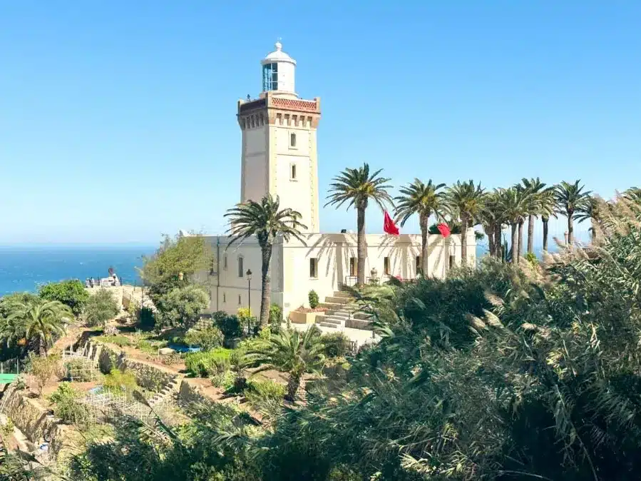 A coastal lighthouse surrounded by palm trees, representing Tangier's scenic beauty for a travel agency promotion.