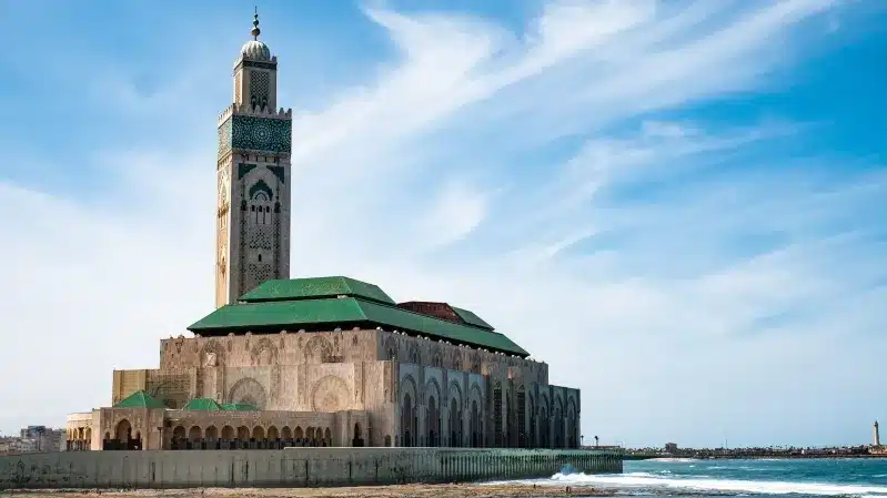 A stunning Islamic mosque situated on the beach, showcasing unique architecture in Casablanca's coastal landscape.