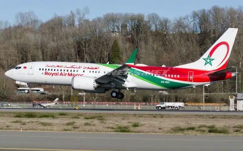 An Algerian airplane from Moroccan Airlines USA taking off from an airport runway against a clear blue sky.