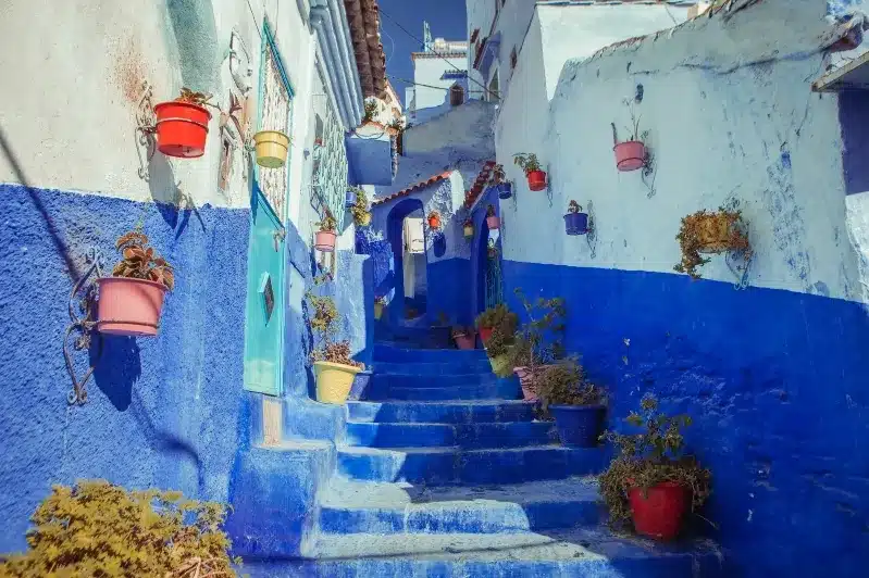 Scenic view of Chefchaouen, Morocco, showcasing its iconic blue buildings, promoted by a Fez travel agency.
