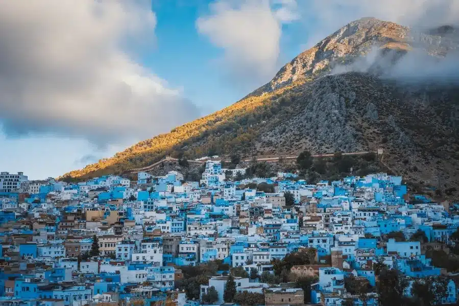 Scenic view of Chefchaouen, Morocco, known for its blue-washed buildings and stunning mountain backdrop, a top travel destination.