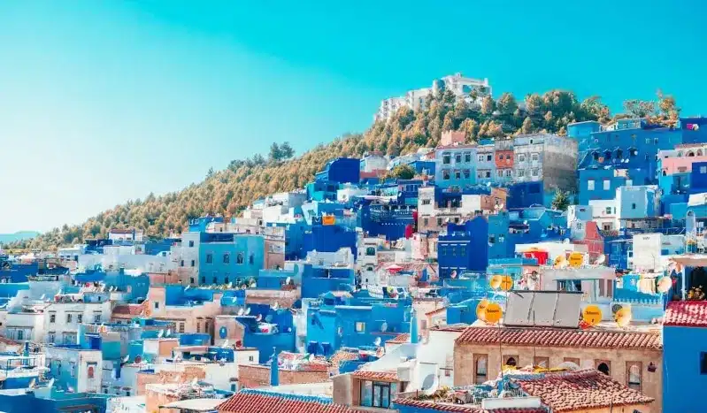 Scenic view of Chefchaouen, Morocco, showcasing its iconic blue buildings and mountainous backdrop, ideal for morocco guided trips.