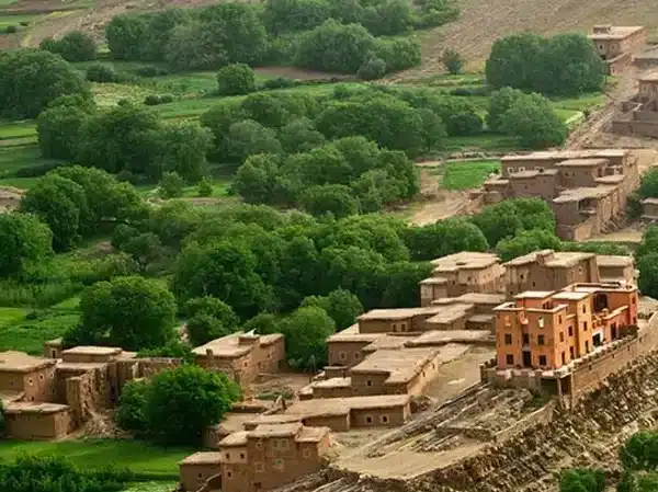 A scenic mountain village nestled in Ait Bouguemez Valley, surrounded by lush green landscapes.
