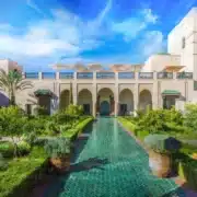 The courtyard of the royal palace in Marrakech, showcasing intricate architecture and lush greenery.