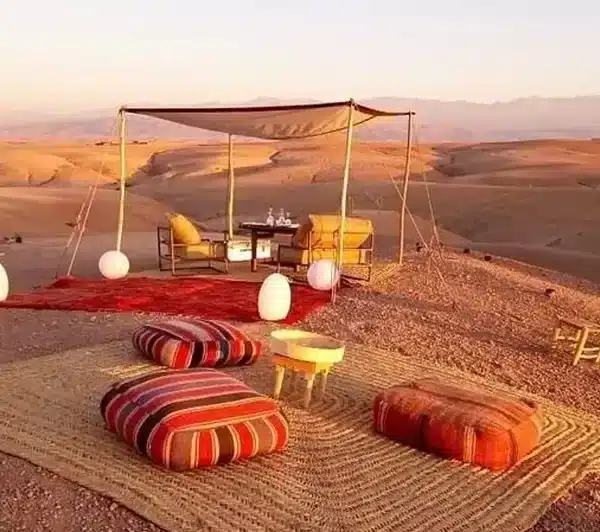A tent in the desert with a table and chairs, set up for a day trip to El Jadida.