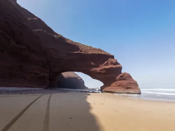 A large rock formation on the beach, showcasing the unique landscape of the Agafay Desert trip.