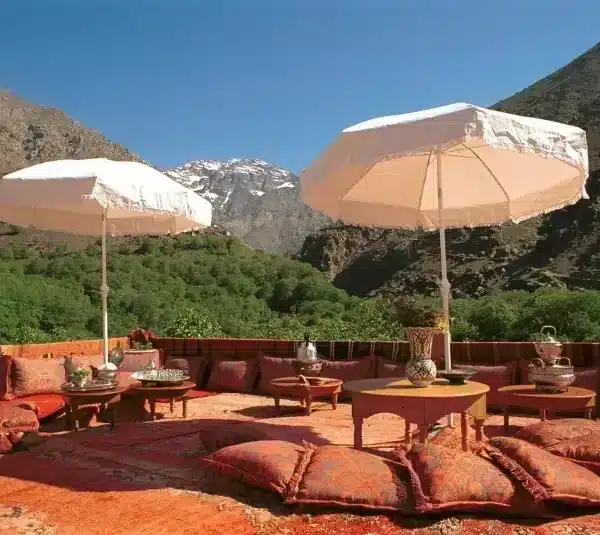 A patio featuring a table and chairs shaded by umbrellas, set for relaxation during the Rabat Day Tour.